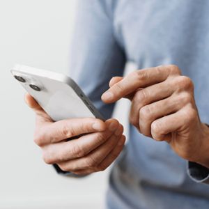 Nahaufnahme einer Person, die ein Smartphone bedient