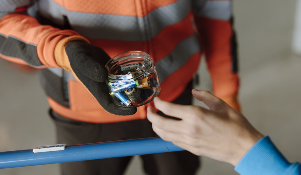 Eine Glasschale gef&uuml;llt mit Batterien wird am WSZ an den Mitarbeiter &uuml;bergeben.