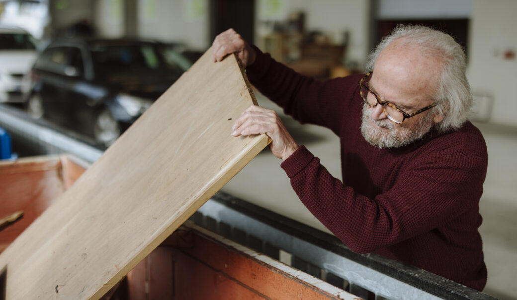&Auml;lterer Herr gibt Holzplatte in WSZ Container.
